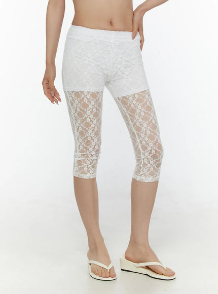 Lace Detail Capri Leggings CL508 White angled front close-up on model showing semi-transparent floral lace lower leg panel with elasticated waistband detail and flip-flops