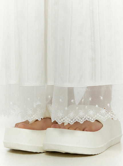 Lace Flared Maxi Skirt CL507 white close-up detail of sheer dotted tulle hem with scalloped embroidered lace edging above platform sandals