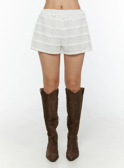 Lace Frill Shorts CU529 White front shot on model showing tiered lace crochet panels elastic smocked waistband and mini fringe trim detail with cowboy boots