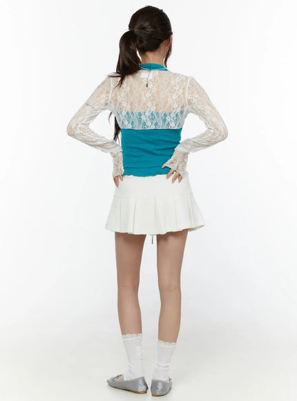 Lace Front-Tie Bolero CL507 White full-body back shot on model hands on hips, sheer lace back with teal layered inner top, white pleated skirt and lace socks
