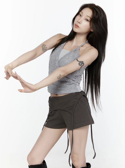 Lace Halter-Neck Top IL522 Gray front shot model in dynamic pose with arms extended showing gray floral lace wrap halter neck detail and dark mini shorts