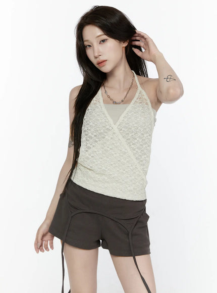 Lace Halter-Neck Top IL522 Ivory front shot model touching hair wearing ivory floral lace wrap halter top with chain necklace and dark mini shorts on white background