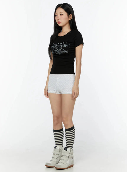 Lace Layered Micro Shorts IU524 White three-quarter side view on model wearing black graphic tee striped knee socks and white wedge sneakers showing side lace silhouette