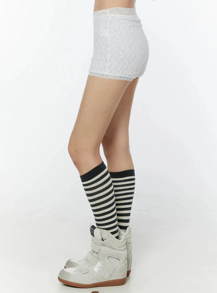 Lace Layered Micro Shorts IU524 White side profile waist-to-ankle shot highlighting side seam lace texture and scalloped hem with striped knee socks and white wedge sneakers