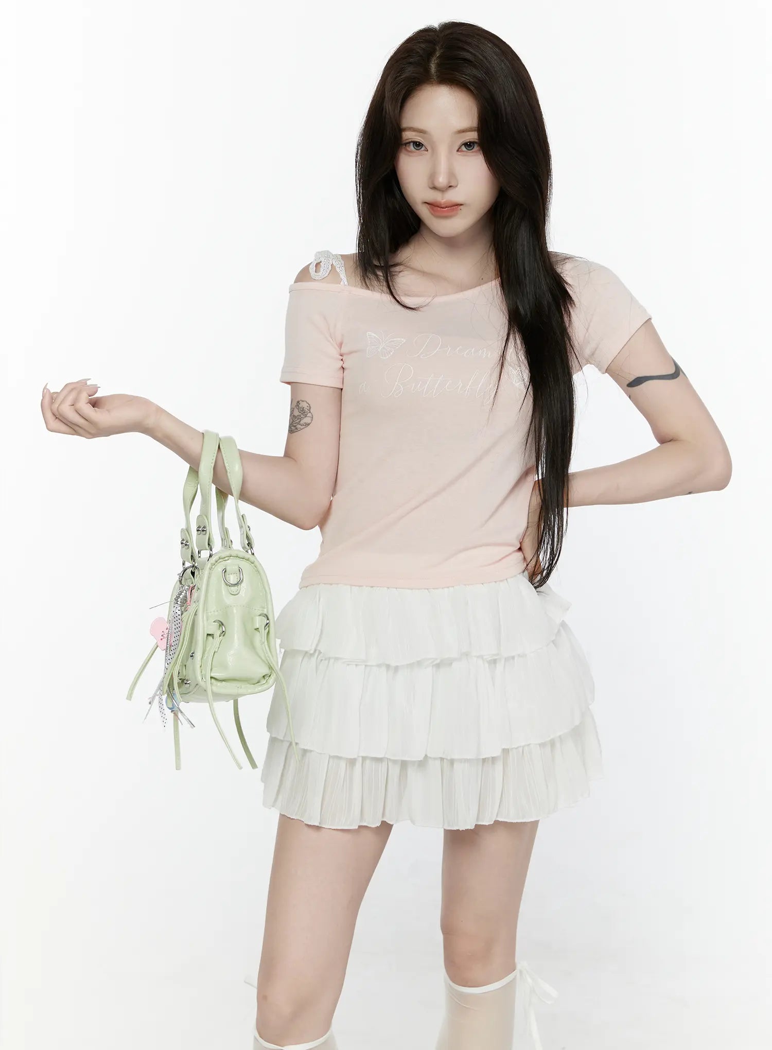 Lace Off-Shoulder Top IL521 Pink front shot on model holding green bag at waist level with asymmetric off-shoulder lace strap detail