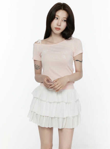 Lace Off-Shoulder Top IL521 Pink front shot on model hands clasped at waist showing off-shoulder lace strap and butterfly script graphic on ribbed top