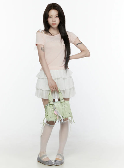 Lace Off-Shoulder Top IL521 Pink full-body front shot on model holding green handbag styled with white tiered ruffle mini skirt and white knee socks