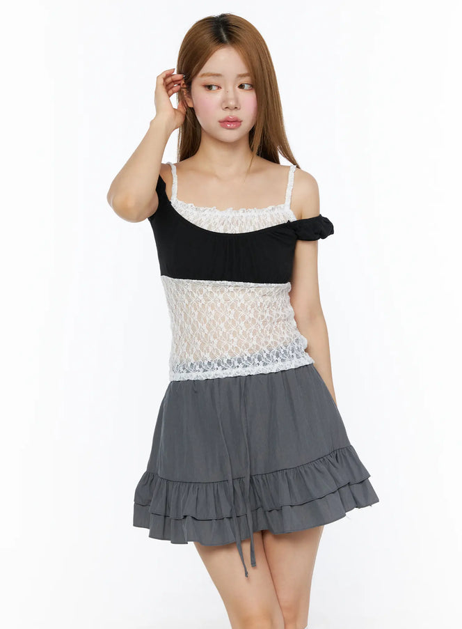 Lace Panel Cami Top CL501 Black front shot on model with arms crossed, styled with gray tiered ruffle mini skirt and knee-high socks