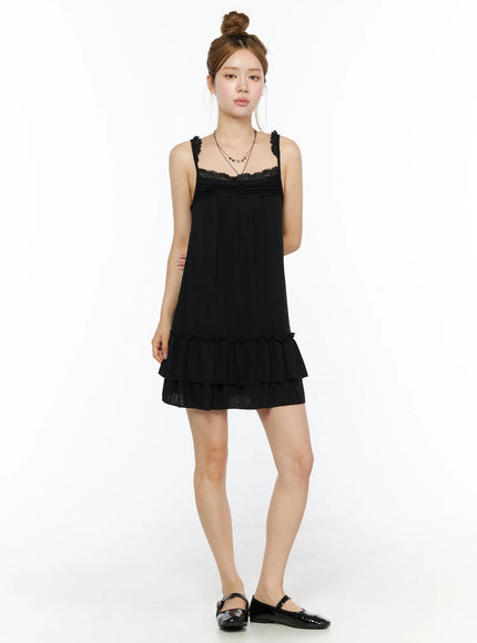 Lace Ruffle Mini Dress CL501 Black full front shot on model standing upright, lace neckline, tiered ruffle hem, paired with mary jane flats