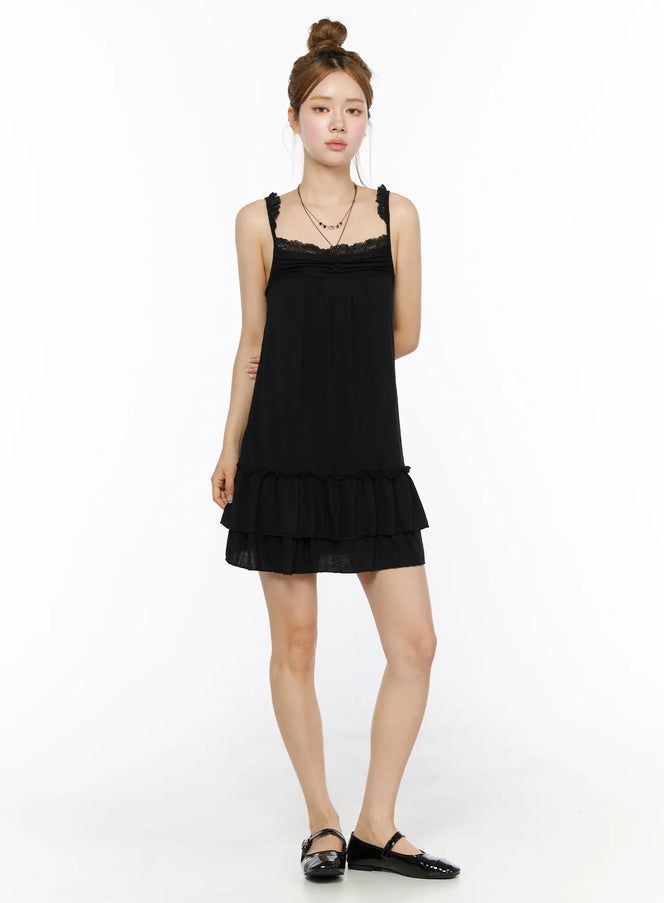 Lace Ruffle Mini Dress CL501 Black full front shot on model standing upright, lace neckline, tiered ruffle hem, paired with mary jane flats