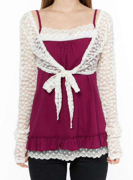 Lace Sheer Crop Cardigan CL502 White close-up front detail shot showing lace bow tie closure, scallop lace trim neckline and sheer floral lace sleeves over magenta cami