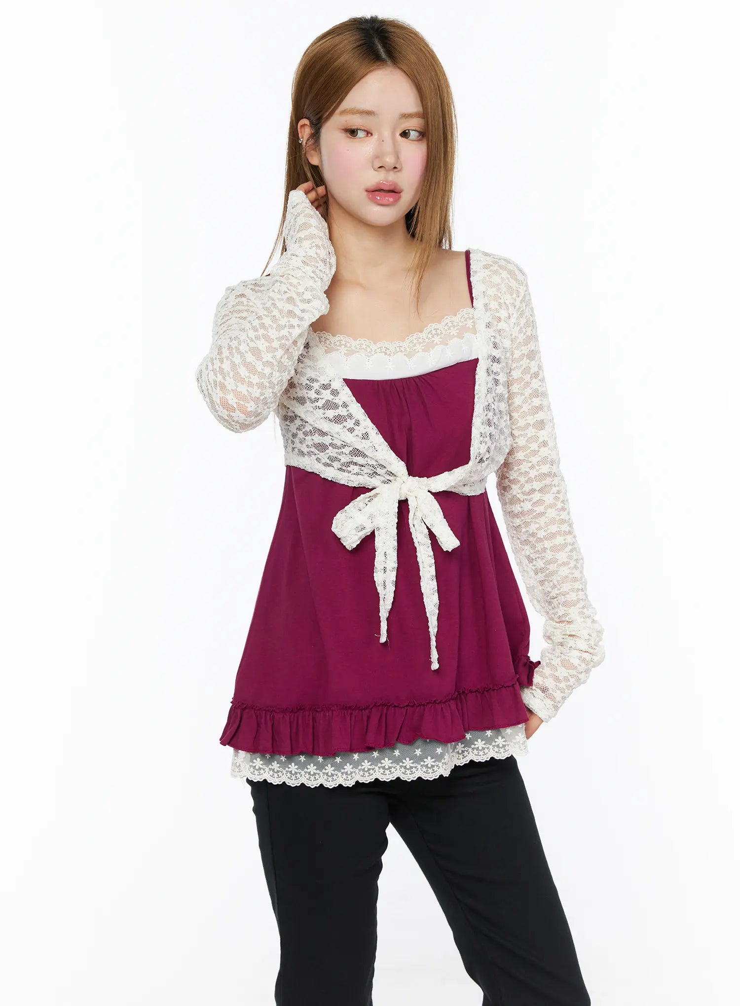Lace Sheer Crop Cardigan CL502 White front shot on model touching ear, three-quarter view highlighting lace wrap front tie and ruffle hem over magenta cami