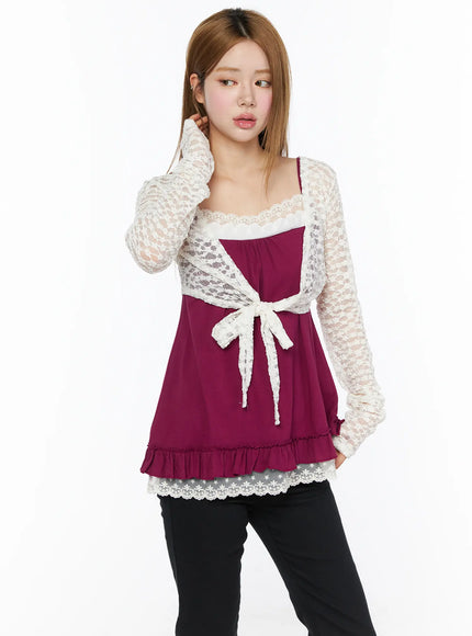 Lace Sheer Crop Cardigan CL502 White front shot on model touching ear, three-quarter view highlighting lace wrap front tie and ruffle hem over magenta cami