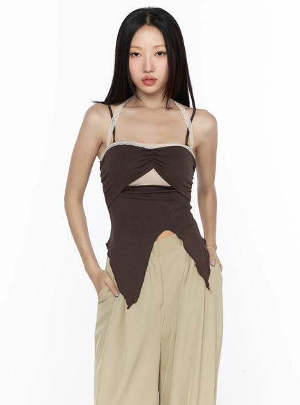 Lace Trim Asymmetric Cami CL524 Brown front shot on model hands in pockets lace trim neckline cutout and asymmetric hem styled with beige wide-leg trousers