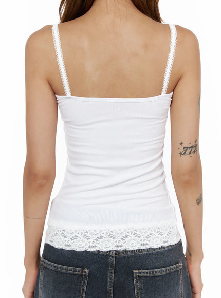 Lace Trim Cami Top CL503 White close-up back detail on model showing ribbed back, lace-edged spaghetti straps, and wide floral lace hem over dark denim waistband