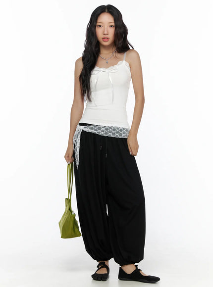 Lace Trim Cami Top CL513 White full-body front on model styled with black balloon pants, green bag, silver necklace, floral lace hem detail visible