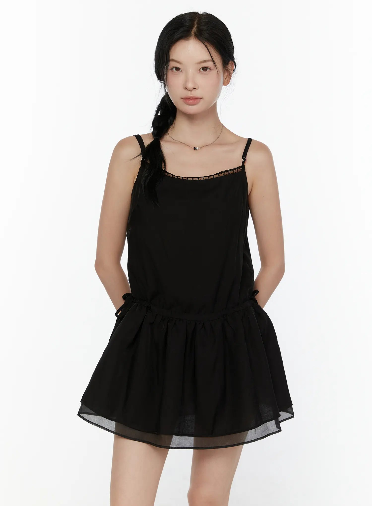 Lace Trim Cami Top CL520 Black front view on model showing spaghetti straps lace neckline trim drawstring waist and double-layer sheer peplum hem worn as mini dress