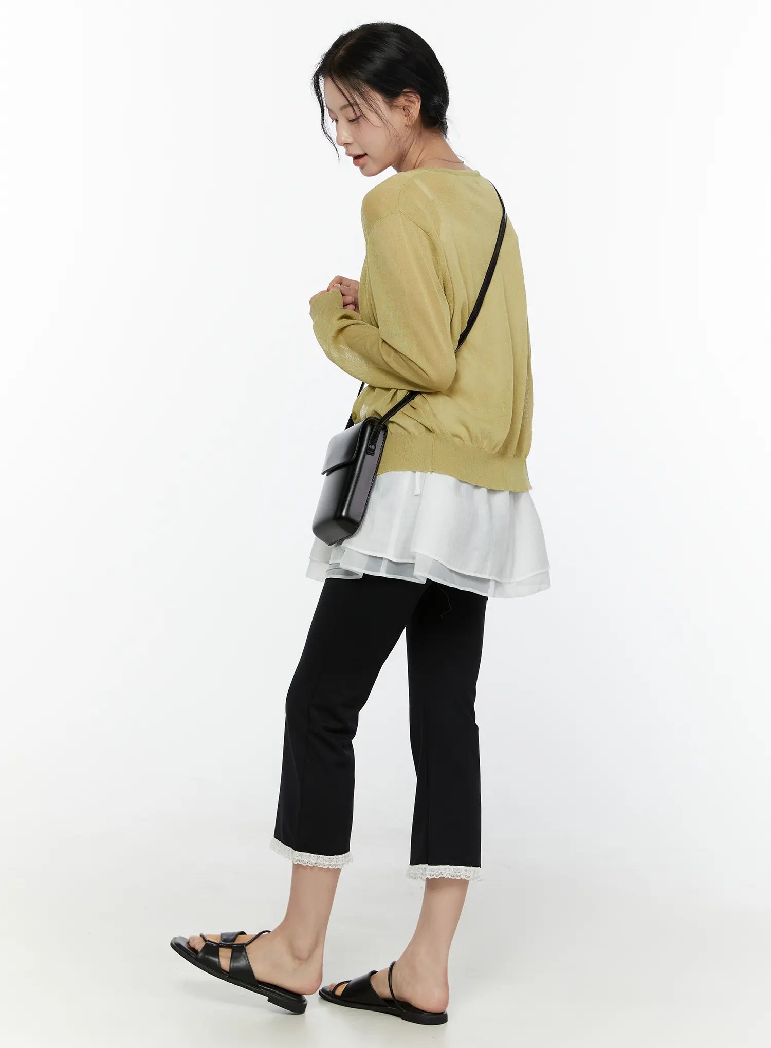 Lace Trim High-Waist Capri Pants CL520 Black three-quarter back styling shot on model wearing yellow cardigan white layered top looking down with black crossbody bag