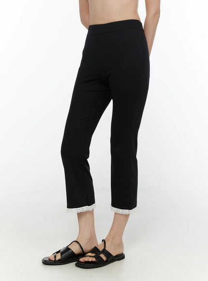 Lace Trim High-Waist Capri Pants CL520 Black side view on model showing cropped flare leg silhouette high waistband and white lace trim hem with black sandals