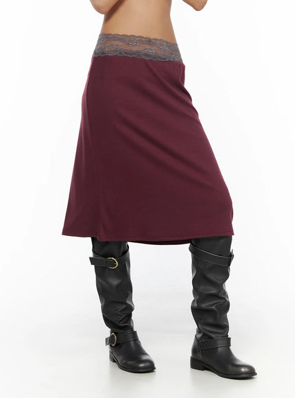 Lace Trim Midi Skirt CL503 Dark red side close-up on model showing A-line midi cut, gray lace waistband, and smooth jersey fabric with black knee-high boots