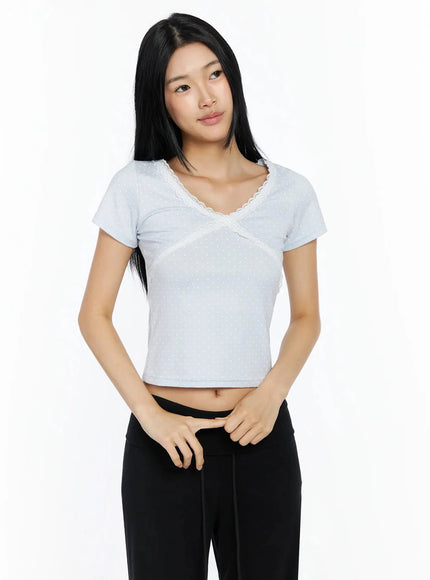 Lace Trim Polka Dot Top IL509 light blue front shot on model with lace V-neckline and cross seam detail, paired with black pants
