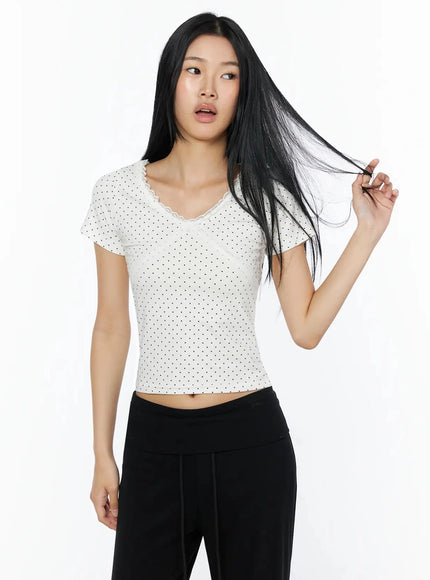Lace Trim Polka Dot Top IL509 White front shot on model with hand in hair, showing lace V-neckline and black polka dot print cropped top