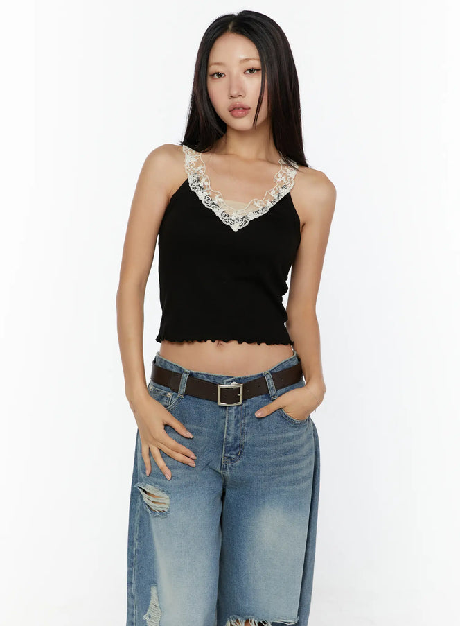 Lace Trim Tank CU526 Black front view on model, floral lace V-neckline trim, ribbed crop tank with lettuce hem, styled with ripped jeans and brown belt