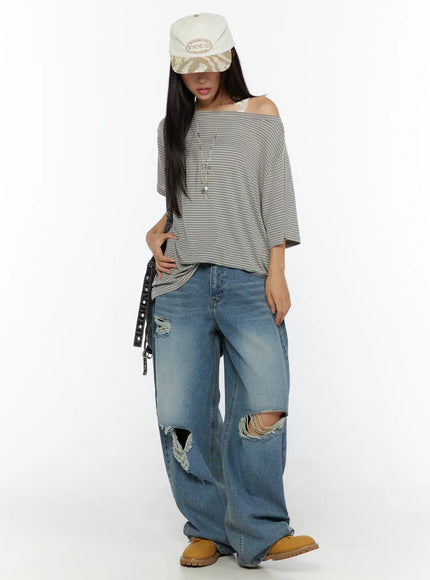 Lace Trim Tank CU526 White styling shot on model layered under grey striped off-shoulder top, lace strap peeking at shoulder, paired with ripped wide-leg jeans