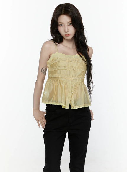 Lace Trim Tank IL521 Yellow front shot on model showing sheer organza tiered ruffle bodice center buttons lace trim hem with black pants