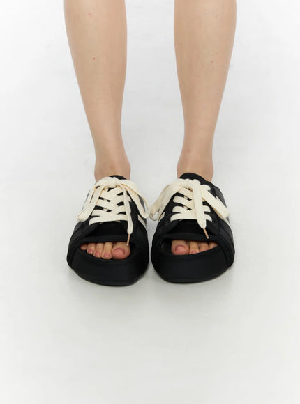 Lace-Up Slide Slippers CU530 Black front view on model standing, showing open toe cutout and chunky cream laces on platform sole