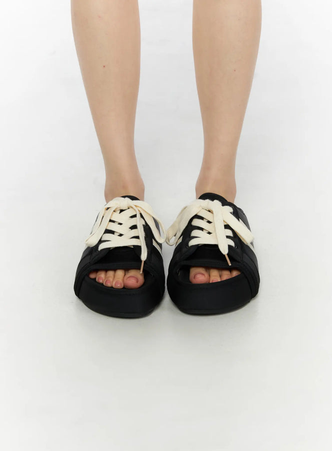 Lace-Up Slide Slippers CU530 Black front view on model standing, showing open toe cutout and chunky cream laces on platform sole
