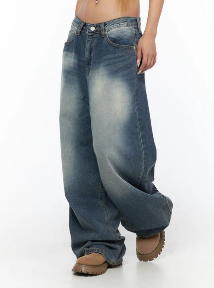 Lane Washed Wide Leg Jeans CU523 Blue side close-up on model showing low-rise waist, wide-leg volume, sand-washed fading across thigh, and pooled hem at boots