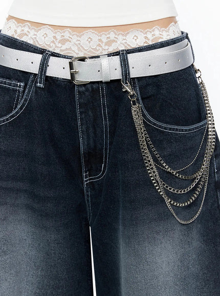 LEWKIN Layered Belt Chain IL516 Silver close-up detail on model showing multi-strand silver chains clipped to white leather belt over dark wash jeans with lace waistband visible