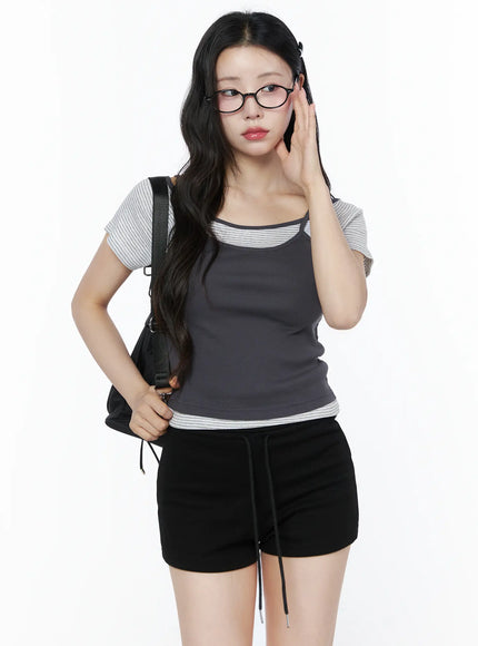 LEWKIN Layered Cami Striped Tee IU525 Dark gray model front shot three-quarter view with backpack and glasses layered cami over stripe tee ribbed fabric S/M