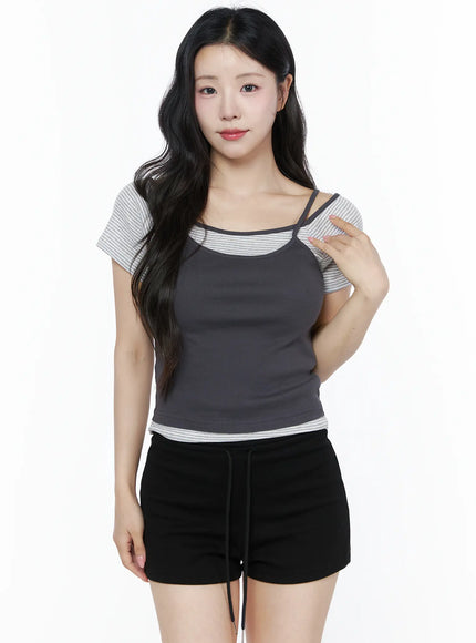 Layered Cami Striped Tee IU525 Dark gray model front shot upper body hand touching shoulder highlighting double cami straps ribbed fabric over gray stripe tee