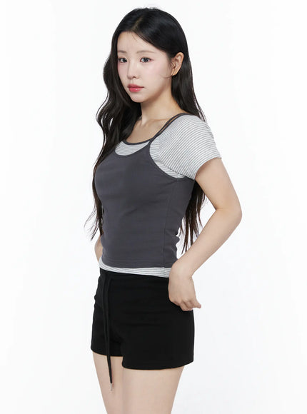Layered Cami Striped Tee IU525 Dark gray model side shot hand in pocket showing slim ribbed cami silhouette layered over striped short sleeve tee cropped hem