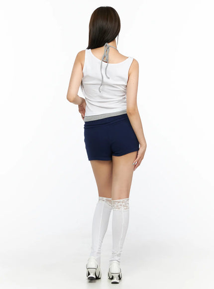 Layered Halter Tank Top CL514 White back view on model showing halter tie detail at neckline and gray banded hem over navy shorts