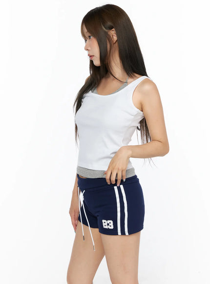 Layered Halter Tank Top CL514 White side view on model facing left showing scoop neckline and gray waistband contrast over navy shorts