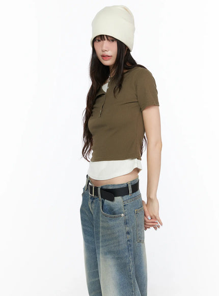 Layered Henley Short Sleeve Tee CL523 Dark green angled side shot on model in beanie, highlighting ribbed crop fit, open button collar and white layered hem with jeans