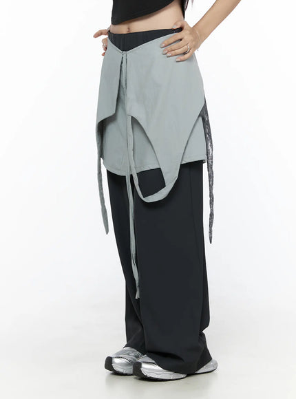 Layered Lace Mini Skirt CL524 Gray side view on model showing asymmetric layered flap, lace trim and ribbon tie over black wide-leg pants