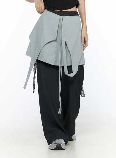 LEWKIN Layered Lace Mini Skirt CL524 Gray back view on model paired with black crop top and wide-leg pants, showing asymmetric drape and ribbon tie detail
