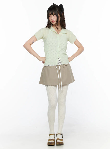 Layered Low-Rise Mini Skirt CL523 Beige full-body front model shot hands on hips styled with mint eyelet cardigan and white diamond patterned tights