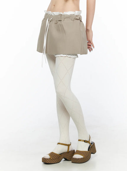 Layered Low-Rise Mini Skirt CL523 Beige side model shot highlighting elasticated paperbag waistband white drawstring and layered ruffle lining detail