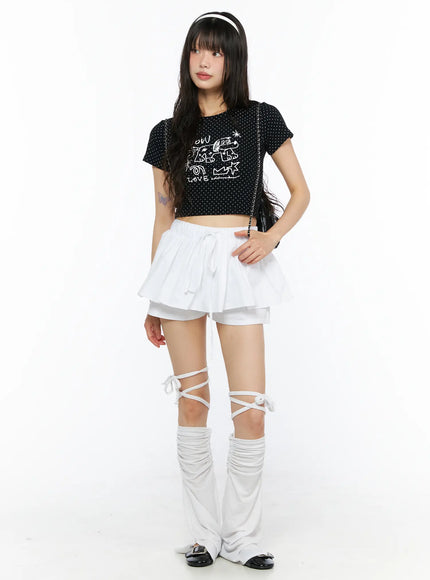LEWKIN Layered Mini Skort CU530 white full-body front shot on model styled with black graphic crop top and lace-up leg warmers