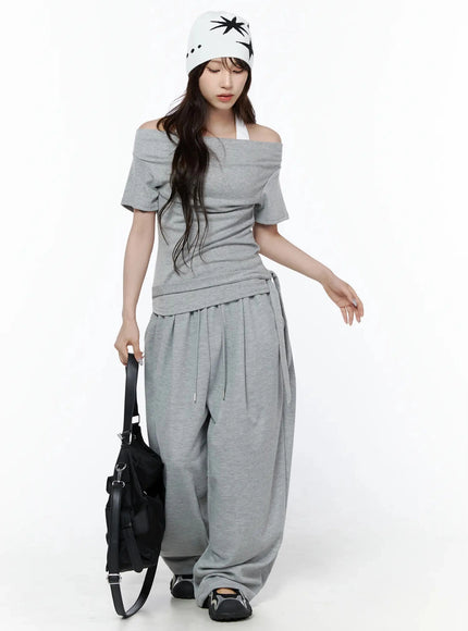 Layered Off-Shoulder Halter Top IL506 Gray full-body front shot on model looking down, styled with wide-leg pants, white star beanie, and black bag
