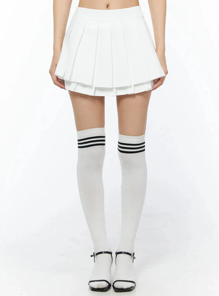 Layered Pleated Skirt IL509 White front waist-down shot on model showing full pleated silhouette with knee-high striped socks and black heeled sandals