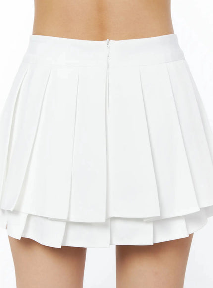 Layered Pleated Skirt IL509 White close-up back detail shot showing back zipper, pleated upper tier, and layered lower pleat hem in smooth woven fabric