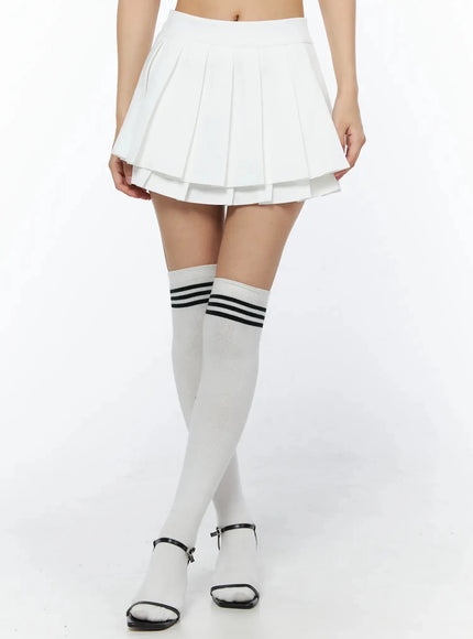 LEWKIN Layered Pleated Skirt IL509 White front close-up on model showing double-layer pleated mini skirt with knee-high striped socks and black heeled sandals