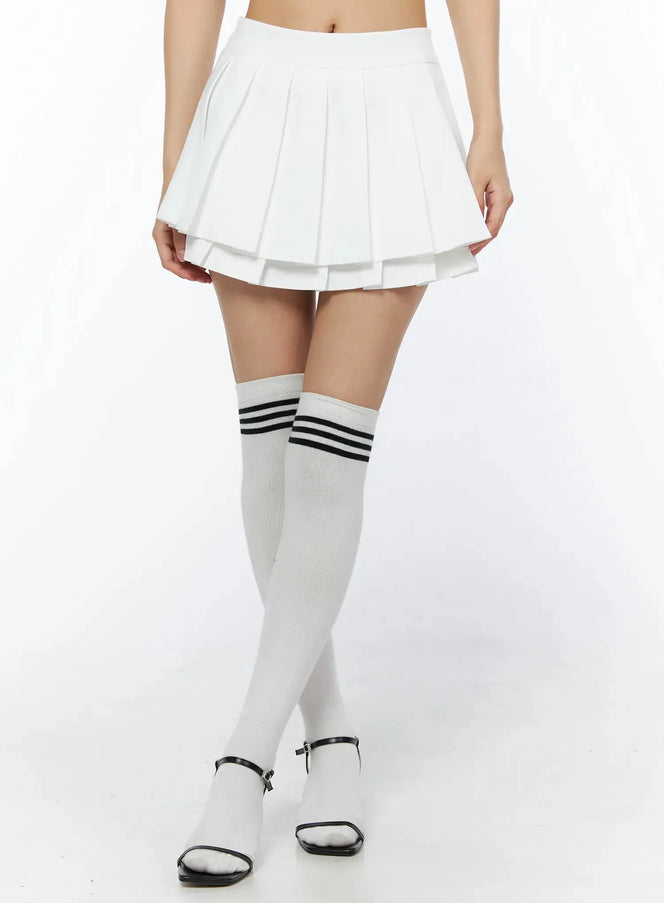 LEWKIN Layered Pleated Skirt IL509 White front close-up on model showing double-layer pleated mini skirt with knee-high striped socks and black heeled sandals