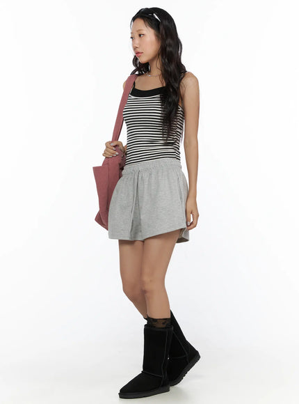 Layered Striped Cami Top CL513 Black side view on model with gray shorts and black boots carrying pink bag gazing to the side